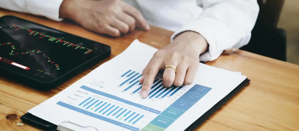 A Brisbane-based business owner analysing valuation documents with charts and a laptop